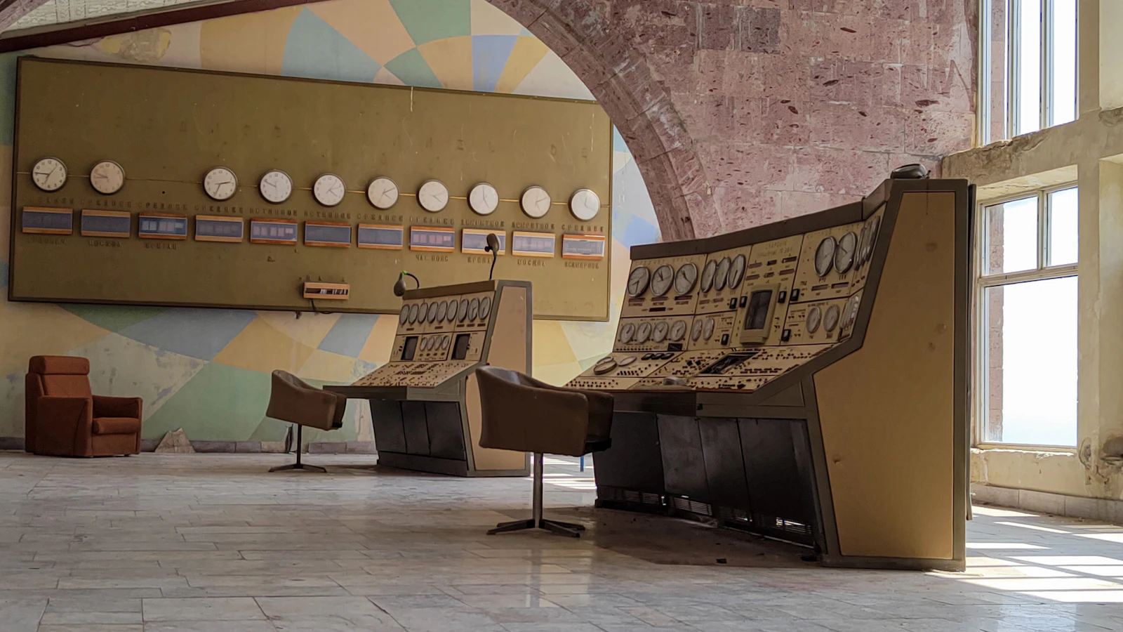 Ancienne salle de contrôle avec pupitres analogiques et synoptique mural