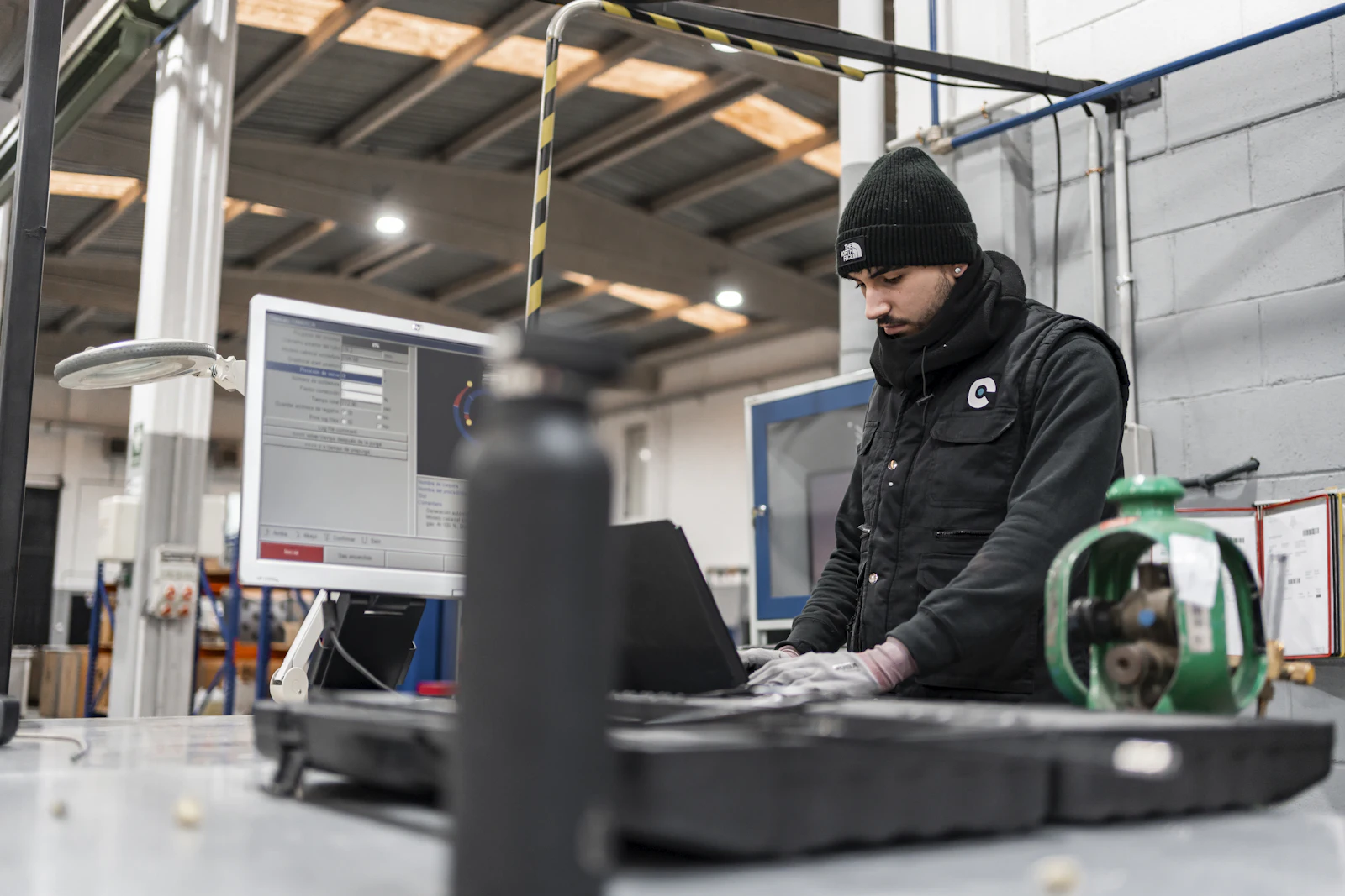 Technicien travaillant sur un ordinateur portable dans un atelier industriel